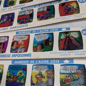 May include: A collection of vintage film strips featuring cartoon illustrations. The strips have colorful panels with text and images, including characters and scenes. The text includes phrases like "Montrez de l'autre côté" and "Peter-Austin Manufacturing Toronto Canada."