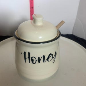 Puede incluir: Un letrero de madera rústica con el texto "Welcome to our home" en letras blancas. El letrero presenta un acabado envejecido y un diseño simple y acogedor, ideal para un porche o entrada.