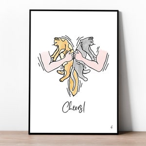 Op de afbeelding: Een ingelijste kunstdruk met een grillige illustratie van twee katten die door armen worden vastgehouden en een hart vormen. Eén kat is oranje en wit, de andere is grijs. Het woord "Cheers!" staat eronder in cursief.