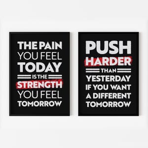 May include: Two black framed motivational posters with white text on a white background. The left poster says "The pain you feel today is the strength you feel tomorrow". The right poster says "Push harder than yesterday if you want a different tomorrow".