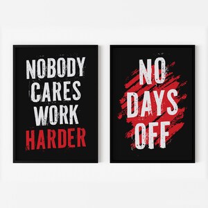 May include: Two black framed motivational posters with white text on a red background. The left poster says "Nobody Cares Work Harder". The right poster says "No Days Off".