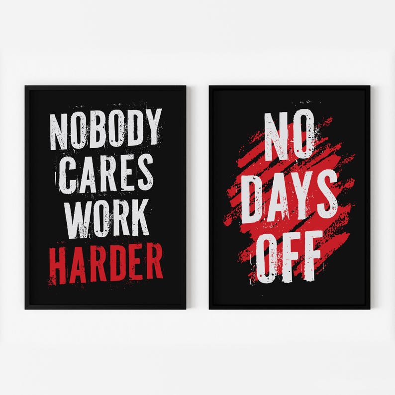 May include: Two black framed motivational posters with white text on a red background. The left poster says "Nobody Cares Work Harder". The right poster says "No Days Off".
