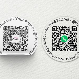 Op de afbeelding: Twee ronde witte stickers met zwart-witte QR-codes. De linker sticker heeft de tekst "www.YourWebsite.com . Your Phone . @YourSocial" en de tekst "me Card" in de QR-code. De rechter sticker heeft de tekst "agica.net . +44 7543 742748 . @nuragicamarketing (insta)" en een groen WhatsApp-pictogram in de QR-code.