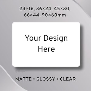 May include: A white rectangular label with rounded corners, featuring the text "Your Design Here" in black. The label is set against a grey background with the text "MATTE • GLOSSY • CLEAR" below. Measurements are listed in millimetres.