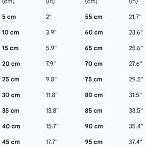 May include: A black text conversion chart on a white background listing measurements in centimeters and inches. The table displays values from 5 cm to 100 cm alongside their corresponding imperial equivalents, starting from 2 inches up to 39.4 inches.