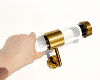 May include: A clear acrylic handrail or curtain rod featuring brushed brass metal brackets and end caps. The cylindrical rod is transparent with a smooth finish, while the metallic components have a matte gold-toned appearance and circular mounting plates.