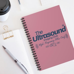 May include: A pink spiral notebook with a blue graphic design that says "The Ultrasound Imaging Club High Frequency Vibes Only" with a registered trademark symbol and the text "ESTD 1985".
