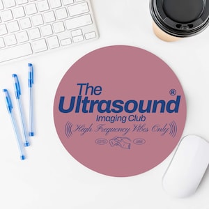 May include: A pink round mousepad with the text "The Ultrasound Imaging Club (High Frequency Vibes Only)" in blue lettering. The text "ESTD 1966" is also in blue lettering.
