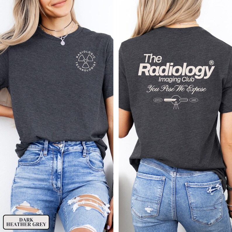 May include: A dark heather grey t-shirt with a white graphic on the front that says "Radiologic Technologist" and a white graphic on the back that says "The Radiology Imaging Club You Pose We Expose".