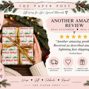 May include: A square gift box wrapped in white paper featuring a repeating pattern of the name Noelle in red and green text, tied with a gold ribbon. The text on the box reads Noelle in various fonts and sizes, creating a festive holiday design.