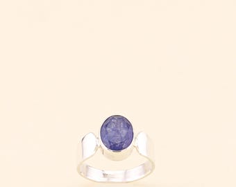 May include: A silver ring with a blue oval gemstone.