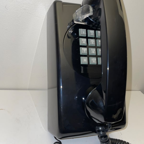 New Old Stock Black Push Button Wall Phone. Never used, still in box.  Perfect condition. Cortelco model 3554, hearing aid compatible.