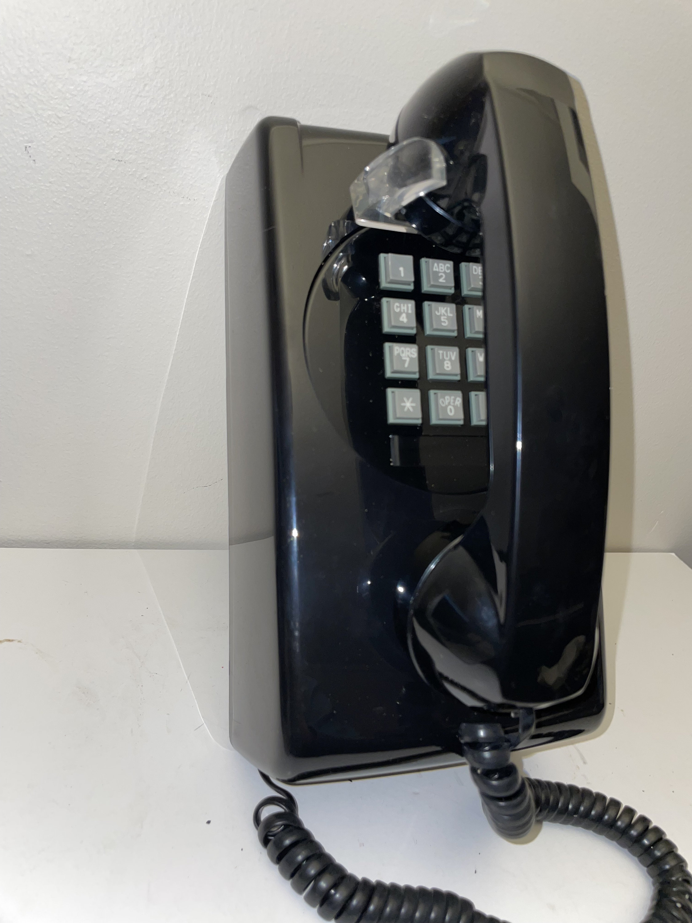 New Old Stock Black Push Button Wall Phone. Never used, still in box.  Perfect condition. Cortelco model 3554, hearing aid compatible.
