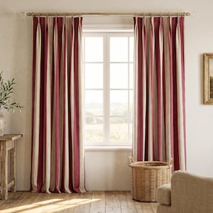 May include: Floor-length curtains featuring vertical stripes in deep burgundy and beige. The fabric is hung from a metallic rod with pinch pleat headers, creating uniform folds that extend from the top down to the bottom of the window frame.