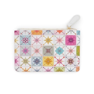 Puede incluir: Un estuche rectangular con cremallera y un colorido estampado floral de azulejos. El patrón presenta varios colores pastel, incluyendo rosa, azul, amarillo y verde, dispuestos en una cuadrícula. El estuche tiene una lengüeta blanca y una cremallera dorada.