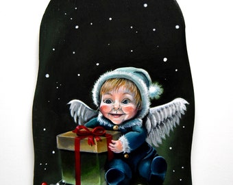 May include: A painted wooden Christmas ornament featuring a cherubic angel with wings holding a wrapped gift. The angel is wearing a blue outfit and a white hat with a fluffy trim. The background is a dark blue with white dots, resembling a starry night.