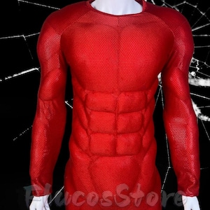Può includere: Un top di costume rosso a maniche lunghe con un motivo a nido d'ape strutturato. Il top presenta una definizione muscolare imbottita sul petto e sulle spalle. Il costume è esposto su un manichino bianco.