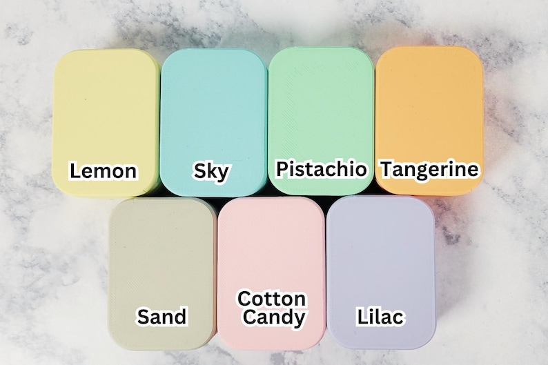 May include: Seven rectangular, rounded-corner objects in pastel colors: lemon, sky blue, pistachio green, tangerine, sand, cotton candy pink, and lilac. Each object has a white label with its color name.