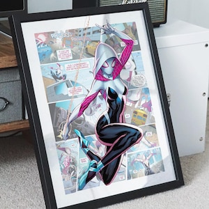 May include: A framed comic book print featuring a female superhero in a white hooded costume with pink accents. She is swinging from a web and has a black and white suit with a spider symbol on her chest. The print is surrounded by other comic book panels.