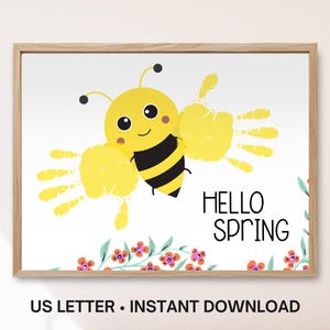 May include: A framed print featuring a cartoon bee with handprint wings. The bee is yellow and black, with a smiling face. The words "HELLO SPRING" are written in black. Floral accents are at the bottom.