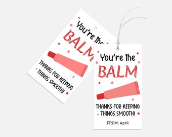 May include: Two white gift tags with red text and a red lip balm illustration. The text on the tags reads "You're the BALM" and "Thanks for keeping things smooth!" One tag also includes the text "FROM: April".