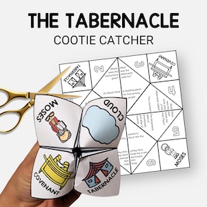May include: A white paper cootie catcher with the text "THE TABERNACLE COOTIE CATCHER" and illustrations of Moses, the Ark of the Covenant, and the Tabernacle. A pair of gold scissors is next to the cootie catcher.
