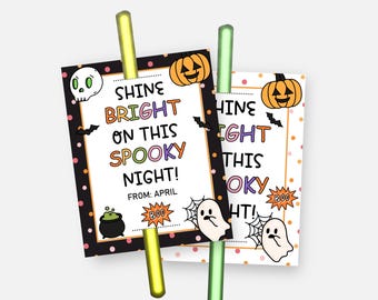 May include: Two Halloween-themed gift tags with the text "SHINE BRIGHT ON THIS SPOOKY NIGHT!" featuring a skull, pumpkin, bats, and ghosts. The tags are held by yellow and green straws.