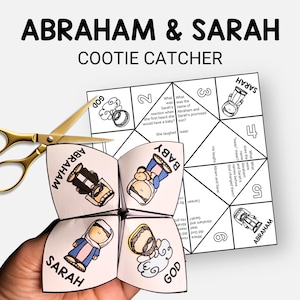 Può includere: Un acchiappa-nani di carta bianca con il testo "ABRAHAM & SARAH" e illustrazioni di Abramo, Sara e un bambino. Un paio di forbici dorate sono accanto all'acchiappa-nani.