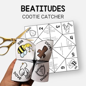 以下が含まれることがあります： 「BEATITUDES COOTIE CATCHER」の文字が入った白い紙のクッキーキャッチャー。 占い師は、蜂、鳩、十字架、盾のイラストで飾られています。 金色のハサミが隣にあります。
