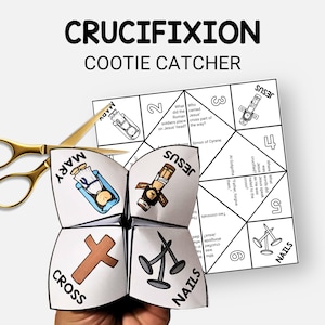 May include: A white paper cootie catcher with the word "CRUCIFIXION" at the top. The cootie catcher has illustrations and text, including "MARY", "CROSS", and "NAILS". Gold scissors are next to the cootie catcher.