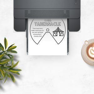 May include: A black and white print of "The Tabernacle" is being printed from a gray printer. The print includes text and an illustration of a tent. A cup of coffee with latte art sits to the right.
