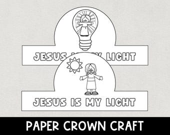 Puede incluir: Corona de papel en blanco y negro con el texto «JESÚS ES MI LUZ». La corona presenta ilustraciones de Jesús dentro de una bombilla y un sol, con las palabras «JESÚS ES MI LUZ».