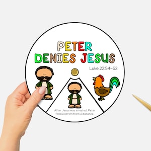 以下が含まれることがあります： 「PETER DENIES JESUS」と「ルカ22:54-62」のテキストが入った円形のイラスト。3人の漫画のキャラクターとオンドリが描かれています。手は、金色のハサミの近くでイラストを持っています。