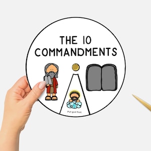 Puede incluir: Ilustración circular de los Diez Mandamientos, sostenida por una mano. La imagen presenta representaciones de dibujos animados de Moisés, las tablas y otros símbolos religiosos. Tijeras doradas en la esquina inferior derecha. El texto "THE 10 COMMANDMENTS" está en la parte superior.