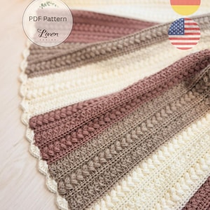 Op de afbeelding: Een gehaakte deken in crème, mauve en bruin, met verschillende getextureerde steekpatronen. De deken heeft een geschulpte rand en de tekst "PDF Pattern Liven Design" in een cirkelvormige afbeelding.