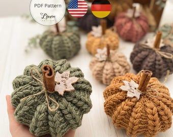 May include: Handmade crochet pumpkins in various fall colors, including green, orange, and brown. Each pumpkin features a cinnamon stick stem and a wooden leaf accent. The pumpkins are part of a PDF pattern by Liven Design.
