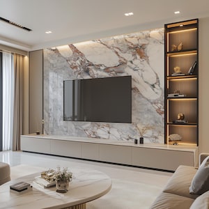 Puede incluir: Un salón moderno con un televisor de pantalla plana grande montado en una pared con acabado de mármol. El televisor está sobre un largo centro de entretenimiento beige con varios cajones. Una pequeña mesa de café redonda con una tapa de mármol blanco se encuentra frente al centro de entretenimiento. Un sofá beige con un cojín está en primer plano.