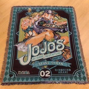 Könnte beinhalten: Eine rechteckige gewebte Decke mit einer farbenfrohen Illustration von Charakteren aus "JoJo's Bizarre Adventure: Stone Ocean". Das Design enthält den Text "JoJo's Bizarre Adventure Part VI Stone Ocean" und die Nummer "02".