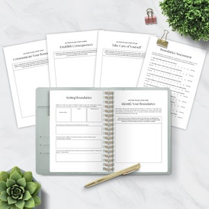 May include: A green and gray spiral bound journal with the title "Setting Boundaries" on the left page and "Identify Your Boundaries" on the right page. The journal is open to a page with a chart for setting boundaries in different areas of life.