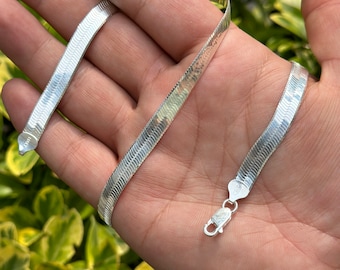 May include: A silver snake chain necklace with a lobster clasp closure.