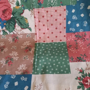 May include: A patchwork fabric featuring a range of floral and geometric designs in shades of red, blue, green, and brown.