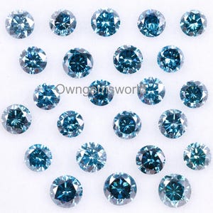 May include: A collection of round, brilliant-cut blue diamonds. The gemstones vary in size and are arranged on a white surface. Each diamond has multiple facets, reflecting light and creating a sparkling effect. The overall color is a deep, vibrant blue.