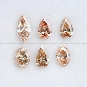 May include: Six loose faceted gemstones in shades of champagne and light brown. The collection includes one marquise cut, two pear cuts, two oval cuts, and one additional pear cut, all displaying brilliant light reflection and clear internal facets.