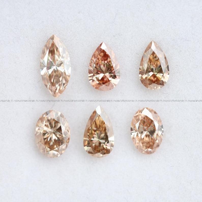 May include: Six loose faceted gemstones in shades of champagne and light brown. The collection includes one marquise cut, two pear cuts, two oval cuts, and one additional pear cut, all displaying brilliant light reflection and clear internal facets.