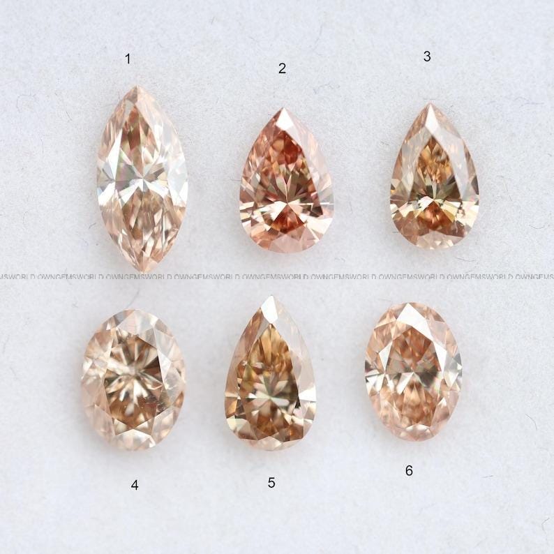 A collection of six loose champagne and cognac diamonds in marquise, pear, and oval cuts, numbered 1 through 6 on a white background.