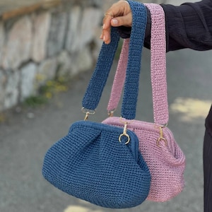 Peut inclure: Deux sacs &agrave; main en crochet avec des sangles r&eacute;glables. Un sac est bleu et l'autre est rose.