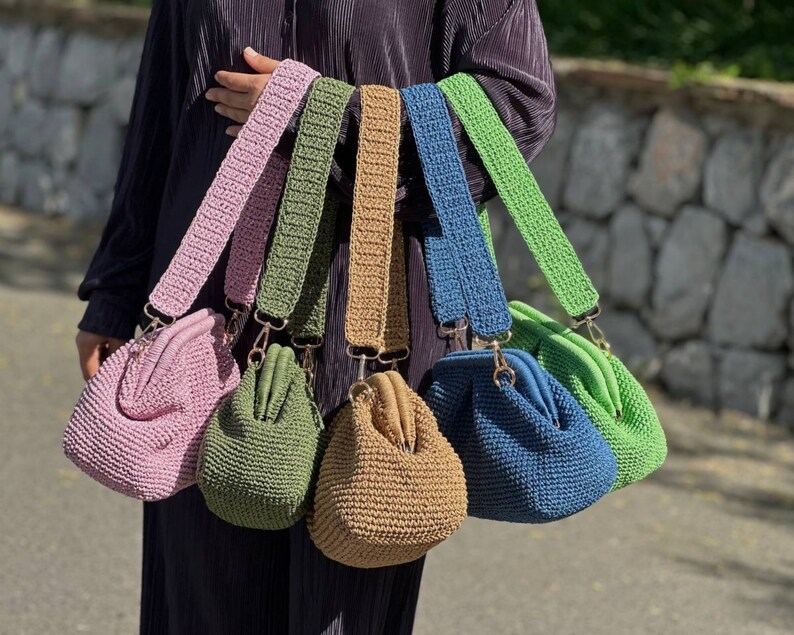 Peut inclure: Cinq sacs &agrave; main en crochet avec des sangles de diff&eacute;rentes couleurs. Les sacs sont rose, vert, marron, bleu et vert. Les sangles sont rose, vert, marron, bleu et vert.