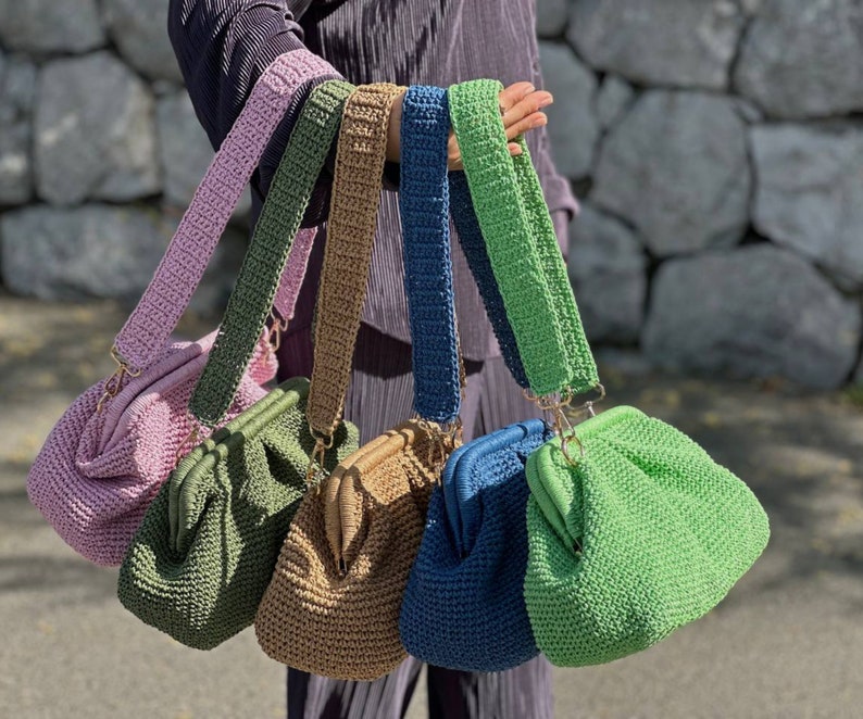 Peut inclure: Cinq sacs &agrave; main en crochet de diff&eacute;rentes couleurs, dont rose, vert, marron, bleu et vert clair. Chaque sac a une bandouli&egrave;re en crochet unique.