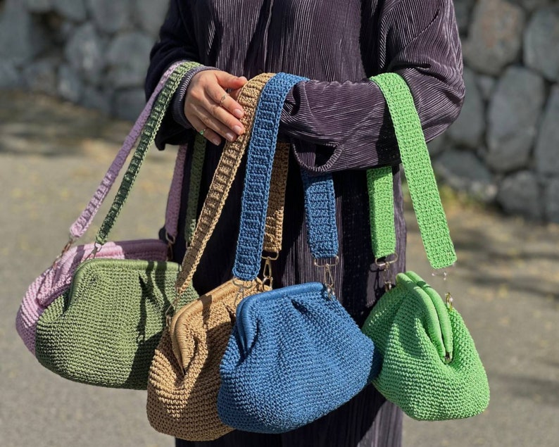 Peut inclure: Cinq sacs &agrave; main en crochet de diff&eacute;rentes couleurs, dont le vert, le bleu, le marron et le rose. Chaque sac a une bandouli&egrave;re en crochet unique et un fermoir dor&eacute;.