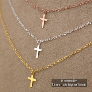 May include: Three delicate necklaces featuring small cross pendants in rose gold, silver, and gold tones. Each necklace has a fine chain link design. The text in the image indicates a 0.4 mm thickness for this specific filigree variant.
